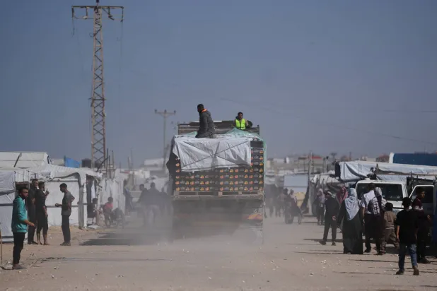 Trucks carrying food, after entering the Gaza Strip through the Kerem Shalom crossing, drive through Khan Younis, Sunday, Feb. 1, 2026. (AP Photo/Abdel Kareem Hana)