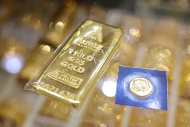 FILE PHOTO: A one-kilogram gold bar and a sealed gold coin are displayed at a jewelry store, in Dubai, United Arab Emirates, January 20, 2026. REUTERS/Amr Alfiky/File Photo
