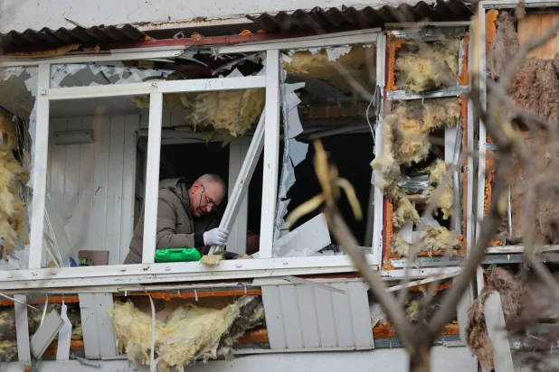 A local resident clears up debris from his broken balcony after a Russian attack in Zaporizhzhia, Ukraine, Wednesday, Jan. 28, 2026. (AP Photo/Kateryna Klochko)