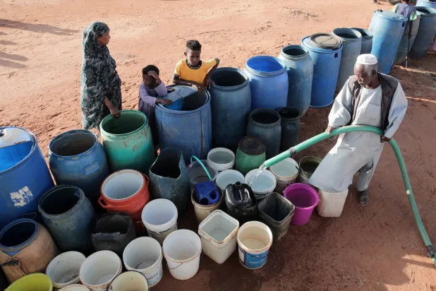 A volunteer fills water containers at a free distribution point, due to water outages in Khartoum, Sudan, Friday, Jan. 30, 2026. (AP Photo/Marwan Ali)