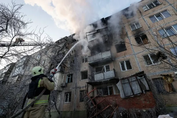 رجال إطفاء يعملون على إخماد نيران بمبنى أصابته مسيّرة روسية في خاركيف الثلاثاء (رويترز)