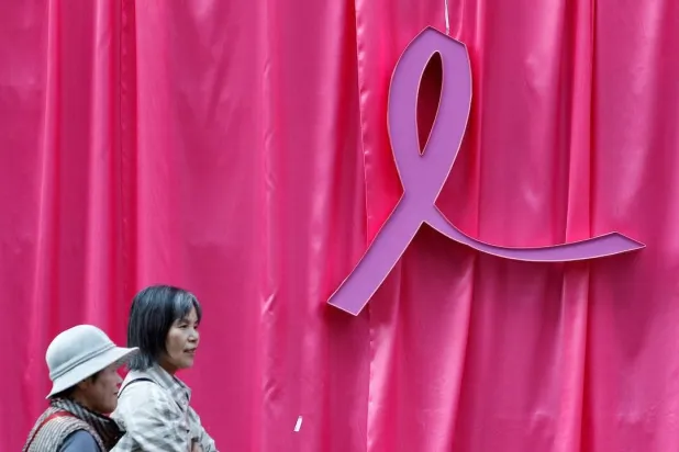 Visitors walk past a sculpture of a pink ribbon installed to promote the "Pink Ribbon" breast cancer awareness campaign in this illustration, October 5, 2011. (Reuters) 