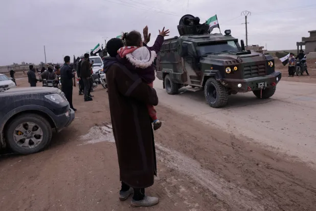 استقبال أهالي القامشلي لقوات الأمن الداخلي التابعة للحكومة السورية التي تستعد لدخول المدينة شمال شرقي سوريا من تل براك قرب الحسكة الثلاثاء (رويترز)
