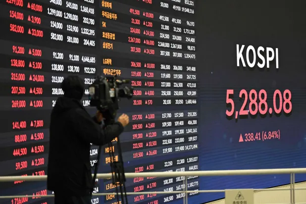 مصور يوثّق شاشة تعرض مؤشر «كوسبي» في بورصة سيول (أ.ف.ب)