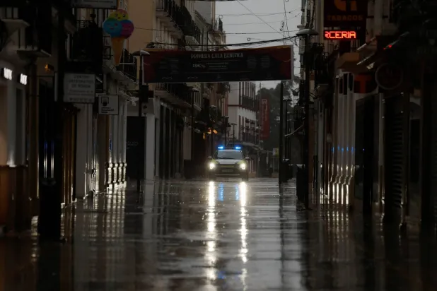 A police car patrols an empty shopping area amid rain as storm Leonardo hits parts of Spain, in Ronda, Spain, February 4, 2026. (Reuters)
