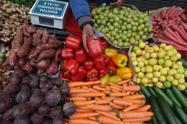 بائع يمسك بحبة من الفلفل الأحمر في الهند (إ.ب.أ)