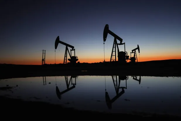 The sun rises behind the Tishrin oil field in the eastern Hasakah countryside, northeastern Syria (AP)