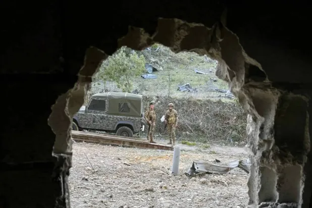 Lebanese army soldiers inspect the site of an Israeli strike in Kfardounine, southern Lebanon (EPA)