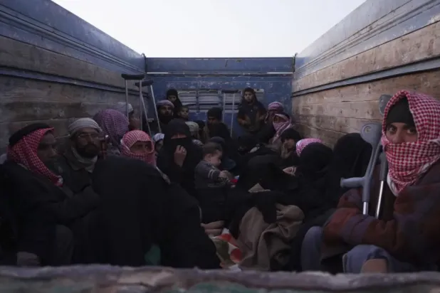 People sit in a truck after being evacuated out of the last territory held by ISIS militants, outside Baghouz, Syria, Monday, March 4, 2019. (AP Photo/Andrea Rosa)
