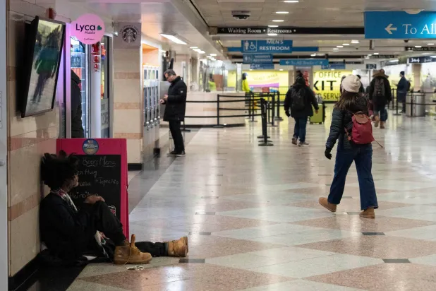 شخص يجلس على أرضية «محطة بن» في نيويورك (أ.ب)