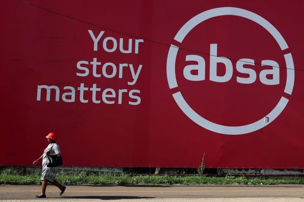 رجل يمر أمام مقر أحد البنوك المحلية في مدينة سويتو بجنوب أفريقيا (رويترز)