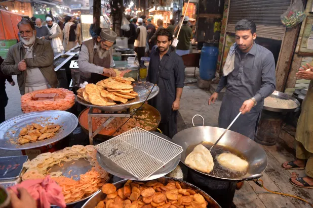 بائعو أطعمة في أحد شوارع مدينة بيشاور الباكستانية (إ.ب.أ)