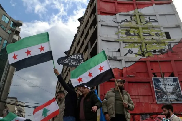 People carry Syrian flags of the opposition as they celebrate the ouster of the Assad regime in Damascus, in Tripoli, northern Lebanon, 08 December 2024. (EPA)
