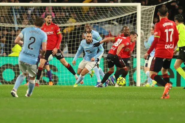 لاعب وسط أوساسونا إيمار أوروز يلعب الكرة تحت ضغط من مهاجم سيلتا فيغو بورخا إيغليسياس (إ.ب.أ).