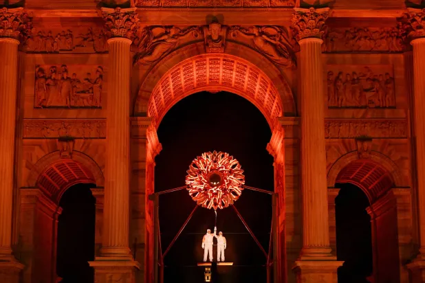 ألبرتو تومبا وديبورا كومبانيوني يحملان الشعلة الأولمبية تحت المرجل في ساحة «آركو ديلا باتشي» وسط ميلانو (إ.ب.أ).