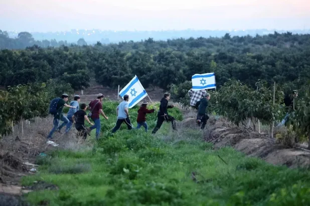 Israeli settlers walk toward the border with Gaza on Thursday (AFP). 