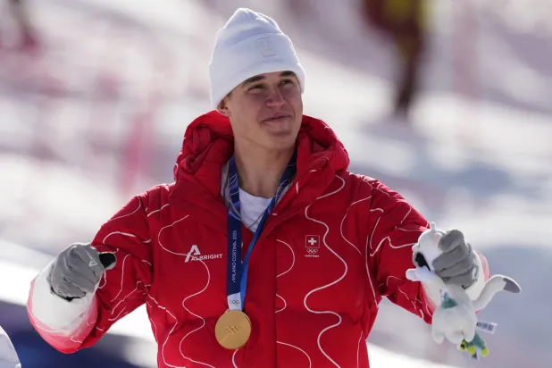 السويسري فرانيو فون ألمن يحتفل بذهبية سباق الانحدار (أ.ب)