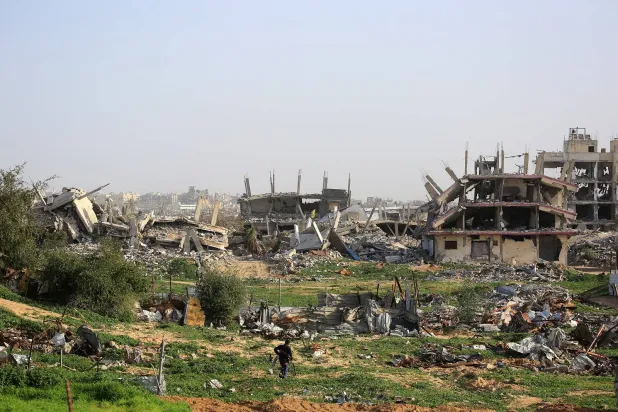 رجل فلسطيني يسير وسط مبانٍ مدمّرة في خان يونس جنوب قطاع غزة (أ.ف.ب)