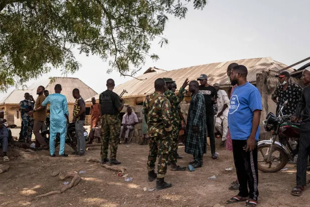 Members of the Nigeria Armed Forces interact with residents following an attack in Woro, Kwara State, on February 5, 2026. (Photo by Light Oriye Tamunotonye / AFP)

