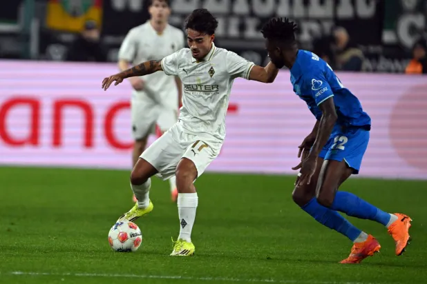 ينس كاستروب لاعب بوروسيا مونشنغلادباخ وإدمون تابسوبا لاعب باير ليفركوزن يتنافسان على الكرة (د.ب.أ)