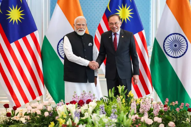 Malaysia's Prime Minister Anwar Ibrahim shakes hands with India's Prime Minister Narendra Modi in Putrajaya on February 8, 2026. (Photo by Hasnoor Hussain / POOL / AFP)