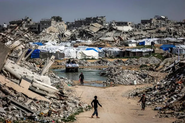 Boys walk past the rubble of destroyed buildings in the Jabalia camp for Palestinian refugees in the northern Gaza Strip on February 8, 2026. (AFP) 