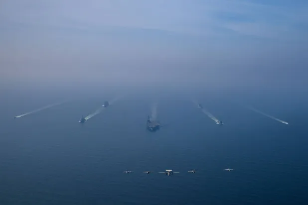 مجموعة حاملة الطائرات الأميركية «أبراهام لينكولن» ترافقها سفينتا إمداد عسكري وقطعتان من خفر السواحل الأميركي تبحر في بحر العرب في حين تحلّق طائرات الجناح الجوي التاسع فوق التشكيل في استعراض للقوة (سنتكوم)