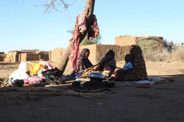 Sudanese displaced people who left El Fasher after its fall, sit in the shade in Tawila at the Rwanda camp reception point on December 17, 2025. (Photo by AFP)