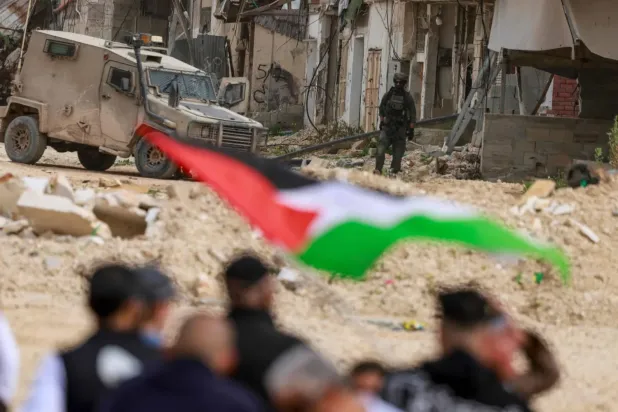 Filistinliler, Batı Şeria'daki Nur Şems mülteci kampının girişini kapatan İsrail askerlerinin önünde gösteri yaptı (AFP)