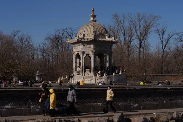 زوار يمرون بجوار جناح بالقرب من أطلال القصر الصيفي القديم المعروف أيضاً باسم يوانمينغ يوان في بكين (أ.ب)