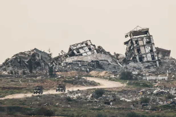 Israeli military vehicles drive past destruction in Gaza, as seen from the Israeli side of the Israel-Gaza border in southern Israel, January 21, 2026. REUTERS/Amir Cohen/File Photo 