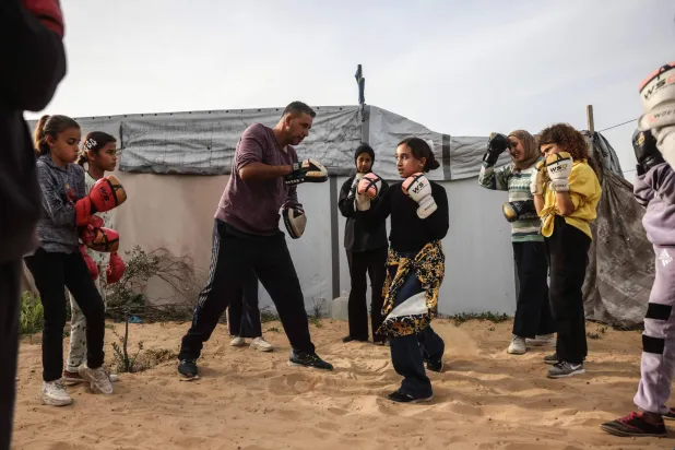 Palestinian girls and young women attend a boxing training session between displacement tents in Khan Younis, in the southern Gaza Strip, on February 9, 2026. (AFP)