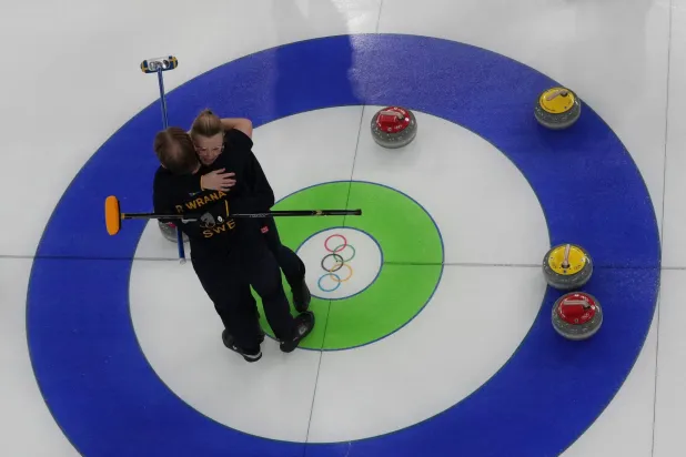 الشقيقان السويديان راسموس وإيزابيلا ورانا يحتفلان بالفوز بالزوجي المختلط للكيرلينج (رويترز)