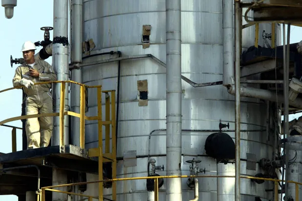 عامل نفط فنزويلي من شركة النفط الحكومية الفنزويلية «PDVSA» يشارك في تعبئة ناقلة نفط بمحطة الشحن والتخزين في خوسيه (رويترز)