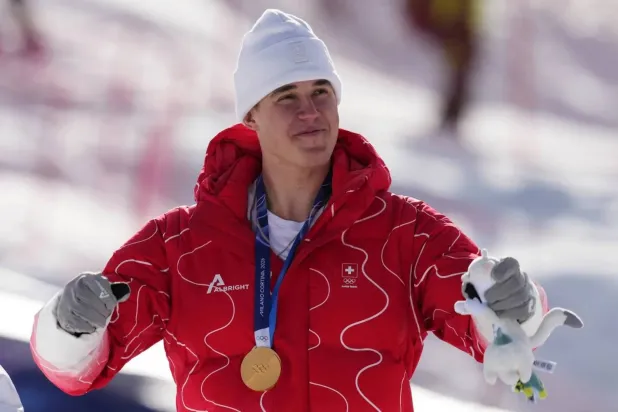 السويسري فرانيو فون ألمن يحتفل بذهبية سباق التعرج (أ.ب)