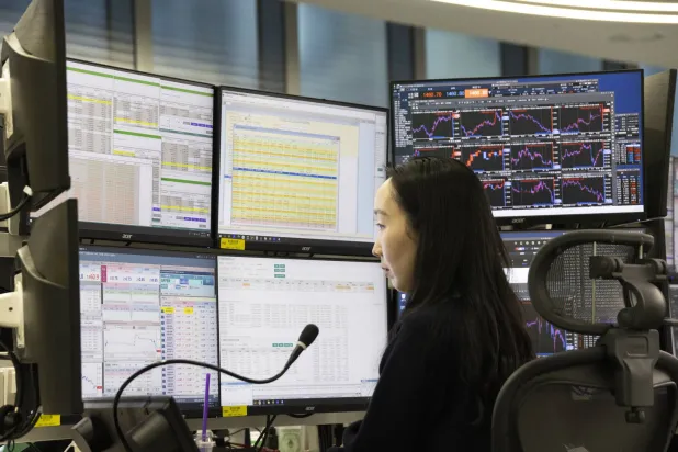 متداولة كورية جنوبية أمام شاشات تعرض مؤشرات الأسهم ببنك هانا في سيول (إ.ب.أ)