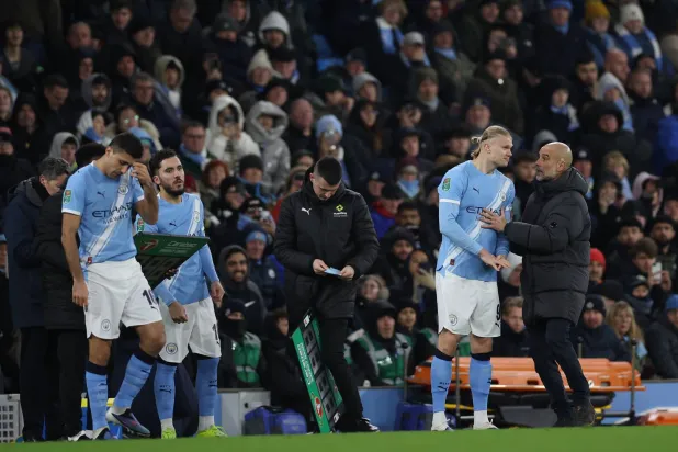 بيب غوارديولا يتحدث مع هالاند (رويترز)