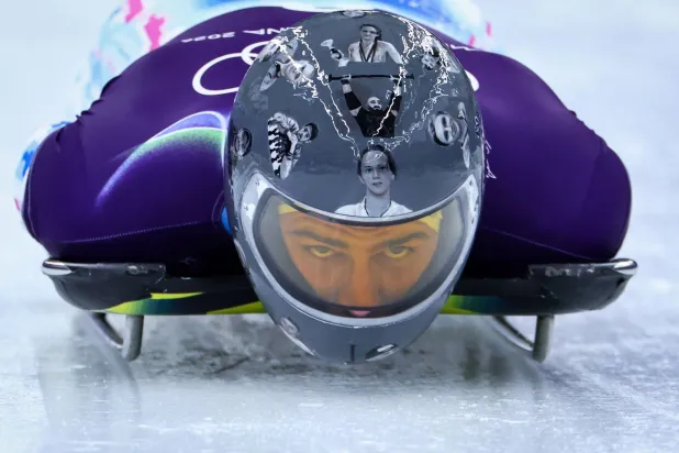 (FILES) Ukraine's Vladyslav Heraskevych wears a helmet which depicts Ukrainian sportsmen and women, victims of his country's war with Russia, as he takes part in the skeleton men's training session at Cortina Sliding Center during the Milano Cortina 2026 Winter Olympic Games in Cortina d'Ampezzo on February 9, 2026. (Photo by FRANCK FIFE / AFP)