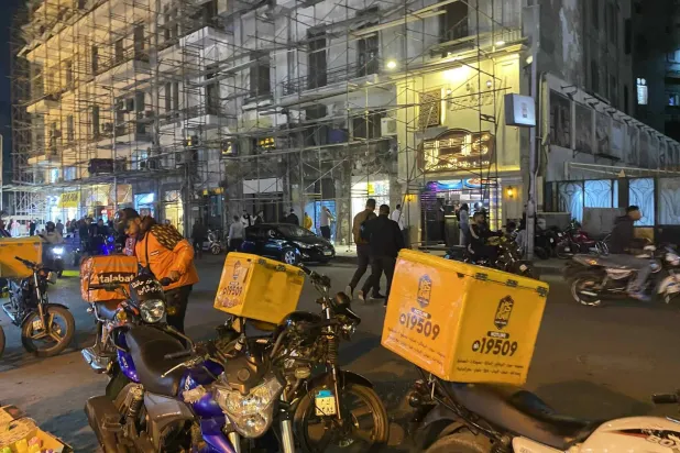 الشاب كريم ياسر خلال انتظاره لطلب من مطعم لتوصيله (الشرق الأوسط)