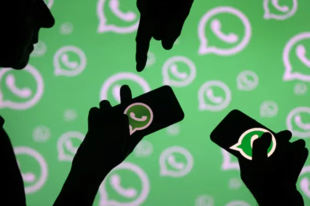 Men pose with smartphones in front of displayed Whatsapp logo in this illustration September 14, 2017. REUTERS/Dado Ruvic/File Photo
