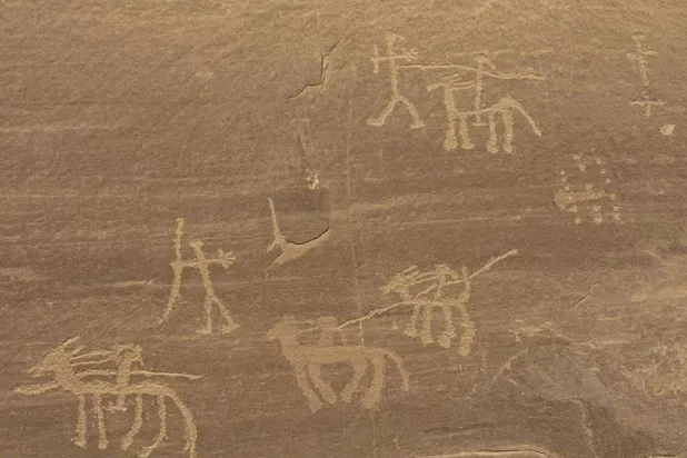 جانب من النقوش والرسوم على الكهف الأثري (وزارة السياحة والآثار)