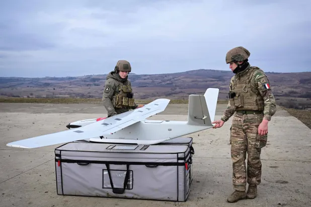 جنديان فرنسيان يُشغلان طائرة مراقبة مُسيرة خلال تدريبات في رومانيا (أ.ف.ب)