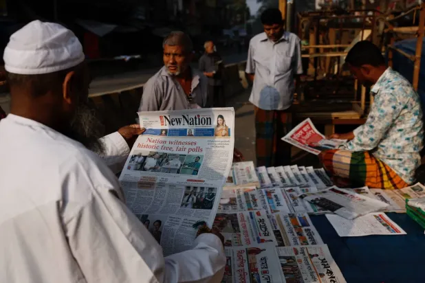 Dakka'da genel seçimlerin ertesi sabahı İngilizce günlük bir gazete okuyan bir kişi, (Reuters)