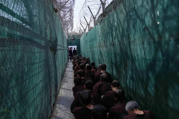 Iraqi security forces lead suspected ISIS militants for questioning, after they were transferred from Syria to Iraq, at Al-Karkh Central Prison in Baghdad, Iraq, Thursday, Feb. 12, 2026. (AP Photo/Hadi Mizban)
