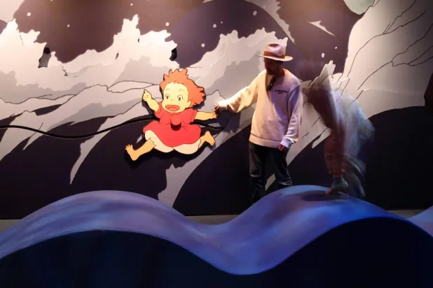 A father and his kid play with an animated character at the Academy Museum Studio Ghibli's "Ponyo" media preview in Los Angeles on February 12, 2026. (Valerie Macon/AFP)