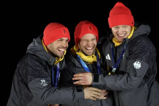 البطلان الأولمبيان الألمانيان توبياس فيندل وتوبياس آرلت مع زميلهما ماكس لانغينهارت (أ.ف.ب)