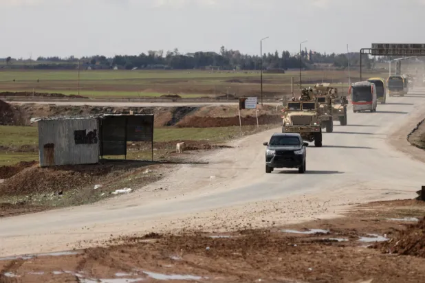 US military vehicles move ahead of buses transporting ISIS detainees from Syria to Iraq, according to a security source from the Syrian Democratic Forces, in Qamishli, Syria. REUTERS/Orhan Qereman 