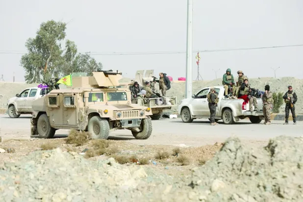 Syrian Democratic Forces members stand by vehicles, as they withdraw from the front lines, following an agreement between the Syrian government and the Syrian Democratic Forces, in Hasakah, Syria, February 10, 2026. REUTERS/Orhan Qereman