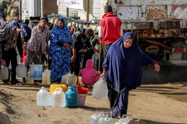 People fill water tanks from a mobile tanker in the Maghazi refugee camp in central Gaza (AFP)