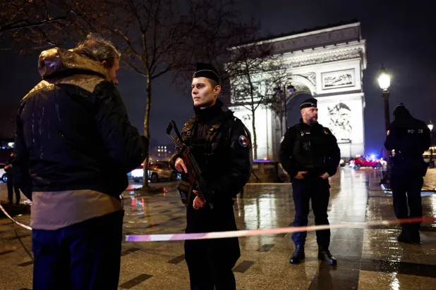 عناصر من الشرطة الفرنسية أمام قوس النصر في باريس (رويترز) 
